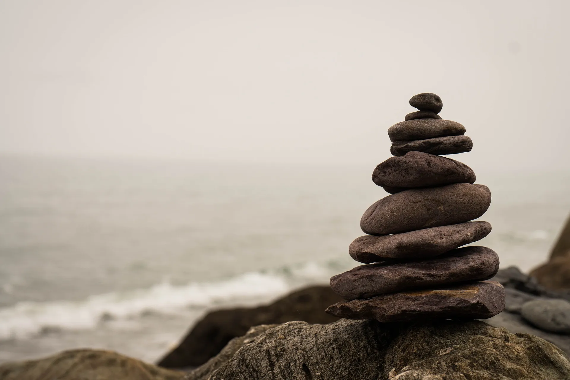A tower of balanced stones beside the sea.